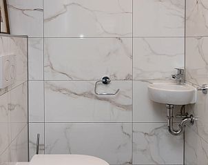 Moderne toiletruimte in Vakantiehuisje in Schoonoord, Zuidoost Drenthe met marmeren tegels.