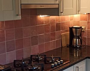 Ruime woonkamer in Huisje in Schoonoord, vakantiehuis in Drenthe, met comfortabele zitbank en eettafel.