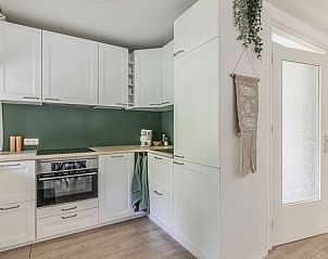 Stijlvolle keuken in Vakantiehuis in Schoonoord, Drenthe met witte kasten en groene achterwand.