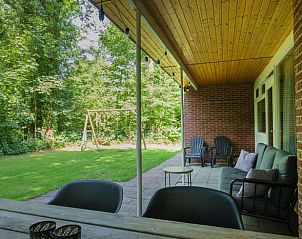Veranda van Vakantiehuis in Schoonoord, Drenthe met zitgelegenheid en uitzicht op tuin.
