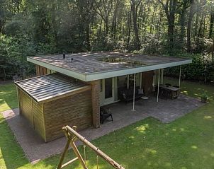 Exterieur van Vakantiehuis in Schoonoord, Zuidoost Drenthe met terras en speeltoestel in bosrijke omgeving.