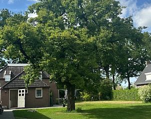 Buitenaanzicht van Vakantiehuis in Schoonoord, Zuidoost Drenthe, met grote bomen.