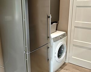 Praktische wasruimte met koelkast en wasmachine in Vakantiehuisje in Oosterhesselen, Drenthe.