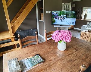 Eettafel met bloemen in Vakantiehuisje in Oosterhesselen, ideaal voor gezellige maaltijden in Drenthe.