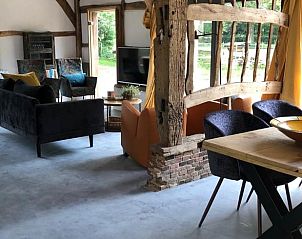 Woonkamer in vakantiehuis Oosterhesselen met comfortabele banken en uitzicht op de tuin in Drenthe.