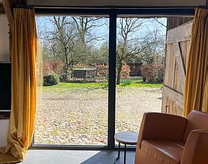 Grote ramen in vakantiehuis Oosterhesselen bieden uitzicht op de natuur van Drenthe.