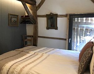 Slaapkamer in vakantiehuis Oosterhesselen met houten balken en comfortabel bed in Drenthe.