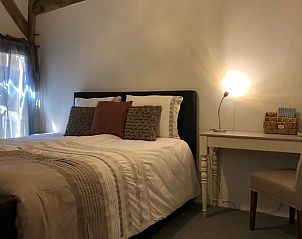 Slaapkamer in vakantiehuis Oosterhesselen met bureau en sfeervolle verlichting in Drenthe.