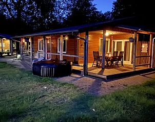 Verlichte veranda bij nacht van Vakantiehuis in Erm, Drenthe, ideaal voor ontspannen avonden.