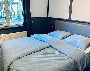 Ruime slaapkamer in Vakantiehuis in Erm, Drenthe, met groot raam en uitzicht op de natuur.