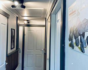 Gang in Vakantiehuis in Erm, Drenthe, met stijlvolle verlichting en decoratieve kunst.