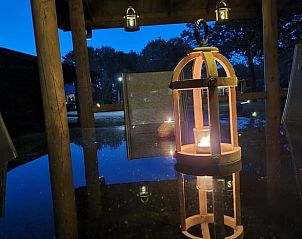 Sfeervolle avond op het terras van Vakantiehuis in Erm, Drenthe, met warme verlichting.