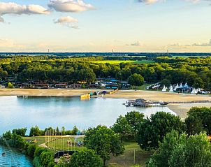 Zandstrand en houten pier in Erm, Drenthe, met rustgevende wateren voor ontspanning.
