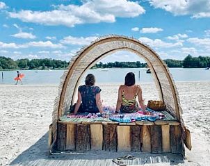 Zandstrand en houten pier in Erm, Drenthe, met rustgevende wateren voor ontspanning.