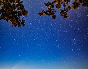 Volle maan boven Erm, Drenthe, met dramatische wolken en nachtelijke hemel.