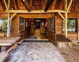 Verwelkomende entree van het Huisje in Erm, een gezellige vakantiewoning in Zuidoost Drenthe, met een rustieke houten veranda.