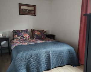 Knusse slaapkamer van Huisje in Geesbrug, vakantiehuis in Geesbrug, Zuidoost Drenthe, met kleurrijke dekens en nachtlampjes.