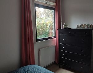 Slaapkamerraam met uitzicht in Huisje in Geesbrug, vakantiehuis in Geesbrug, Zuidoost Drenthe, met dressoir en gordijnen.