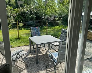 Uitzicht op de tuin vanuit de binnenruimte van Huisje in Geesbrug, vakantieverblijf in Drenthe.