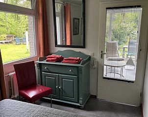 Slaapkamer met uitzicht op tuin in Huisje in Geesbrug, vakantieaccommodatie in Drenthe.