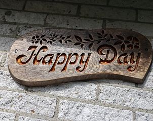 Decoratief bord met 'Happy Day' op de muur van Vakantiehuisje in Geesbrug, Drenthe.