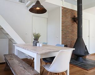 Eettafel met houten bank en stoelen in Vakantiehuisje in Geesbrug, Drenthe.