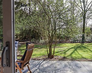 Terras met houten tuinmeubilair in de tuin van Vakantiehuisje in Geesbrug, Drenthe.