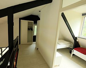 Lichte slaapkamer in Vakantiehuis Geesbrug, Drenthe met uitzicht op de natuurlijke omgeving.