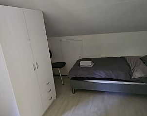 Slaapkamer in Geesbrug vakantiehuis, Drenthe met tweepersoonsbed en opbergruimte.