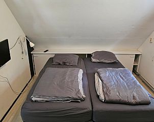 Comfortabele slaapkamer in Geesbrug vakantiehuis, Drenthe met televisie en tweepersoonsbed.