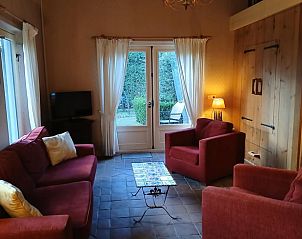 Gemtliches Wohnzimmer im Ferienhaus in Stieltjeskanaal, Sdost-Drenthe, mit bequemen Sitzgelegenheiten und Gartenblick.