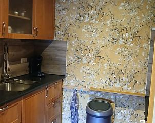 Gemtliche Kche im Ferienhaus in Stieltjeskanaal, Sdost-Drenthe, mit Holzschrnken und schnen Tapeten fr eine heimelige Atmosphre.