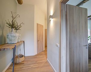 Stijlvolle hal van Huisje in Benneveld, Zuidoost Drenthe, met houten vloer en decoratieve elementen.