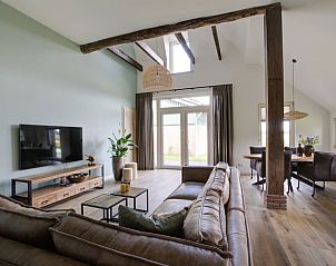 Gezellige woonkamer in Huisje in Benneveld, Zuidoost Drenthe, met comfortabele banken en grote ramen.