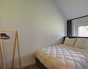 Sfeervolle slaapkamer in Huisje in Benneveld, Zuidoost Drenthe, met comfortabel bed en minimalistisch ontwerp.