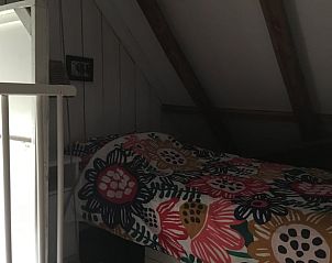 Knusse slaapruimte in Vakantiehuis in Benneveld, Zuidoost Drenthe, met schuin dak en houten details.