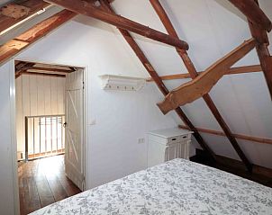 Slaapkamer met houten balken in Vakantiehuis in Benneveld, Zuidoost Drenthe, biedt rustieke charme.