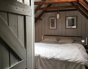 Romantische slaapkamer in Vakantiehuis in Benneveld, Zuidoost Drenthe, met houten details en kunst.