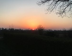 Adembenemende zonsondergang bij Vakantiehuis in Benneveld, Zuidoost Drenthe, over de uitgestrekte velden.