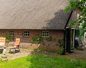 Rustiek terras bij Huisje in Benneveld, vakantieverblijf in Drenthe met traditionele architectuur.