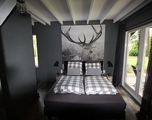 Sfeervolle slaapkamer in Vakantiehuisje in Erica, Drenthe, met uitzicht op de tuin.