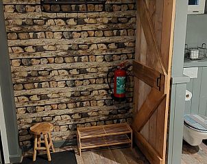 Ingang van Vakantiehuisje in Erica, Drenthe, met rustieke houten accenten.