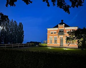 Vakantiehuisje in 2e Exloermond, Drenthe, sfeervol verlicht in de nacht met een serene uitstraling.