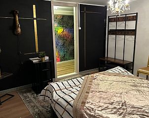 Moderne slaapkamer in Vakantiehuisje in 2e Exloermond, Drenthe, met unieke wanddecoratie en luxe uitstraling.