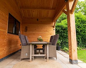 Overdekte veranda van Vakantiehuis in Klijndijk, Drenthe met houten tafel en stoelen.