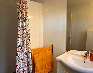 Frisse badkamer in vakantiehuis Klijndijk, Drenthe, met kleurrijke douchegordijn en wastafel.