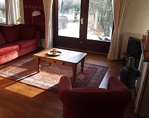 Comfortabele woonkamer met rood interieur in Vakantiehuis in Odoornerveen, Zuidoost Drenthe, Drenthe.