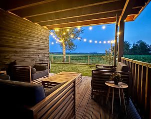 Sfeervolle avondverlichting op het terras van Vakantiehuisje in Odoornerveen, Zuidoost Drenthe, met uitzicht op de omliggende natuur.