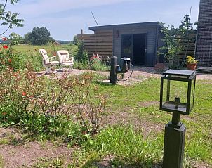 Groene tuin bij Vakantiehuis in Zwinderen met comfortabele stoelen in Zuidoost Drenthe.