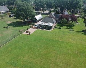 Luchtfoto van Huisje in Fluitenberg, vakantiehuis in Zuidwest Drenthe, met uitgestrekte groene velden.